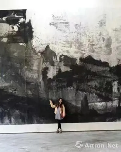 观众站在高大的水墨作品前，照片保留原始水印