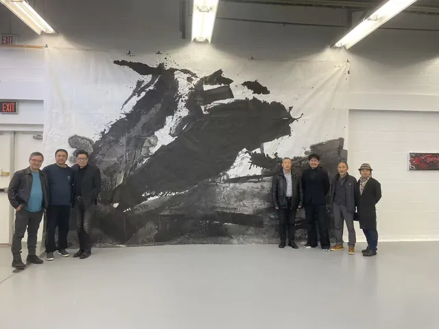 2023年加拿大生命之墨展览现场，多人在大型水墨作品两侧合影