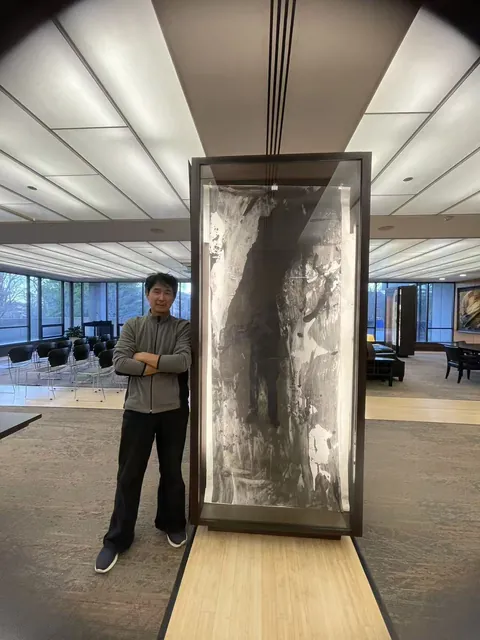 室内立式框架中的竖幅水墨作品与旁边人物