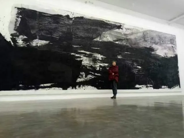 观众站在长幅水墨作品前，展厅地面映出画面