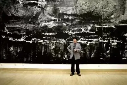 人物站在横向大型水墨作品前