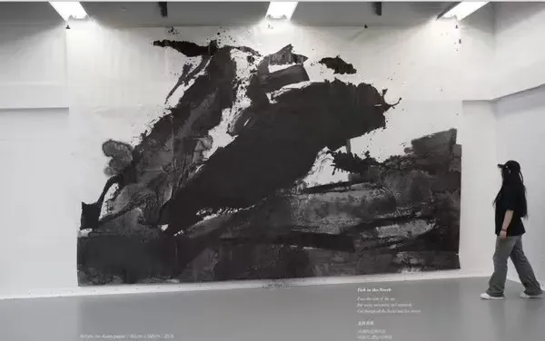 展厅中观众走过大型水墨作品的照片